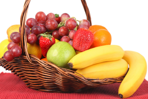 A basket full of fruit in front of white background.